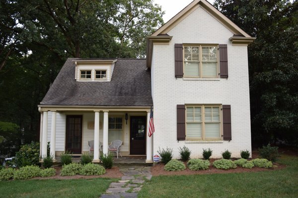Tucker's Home Services — BEFORE photo of a white brick Woodstock home with dated tan trim and weathered shutters prior to exterior refresh